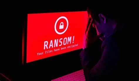 Persona frente a una pantalla con un aviso de ataque de ransomware